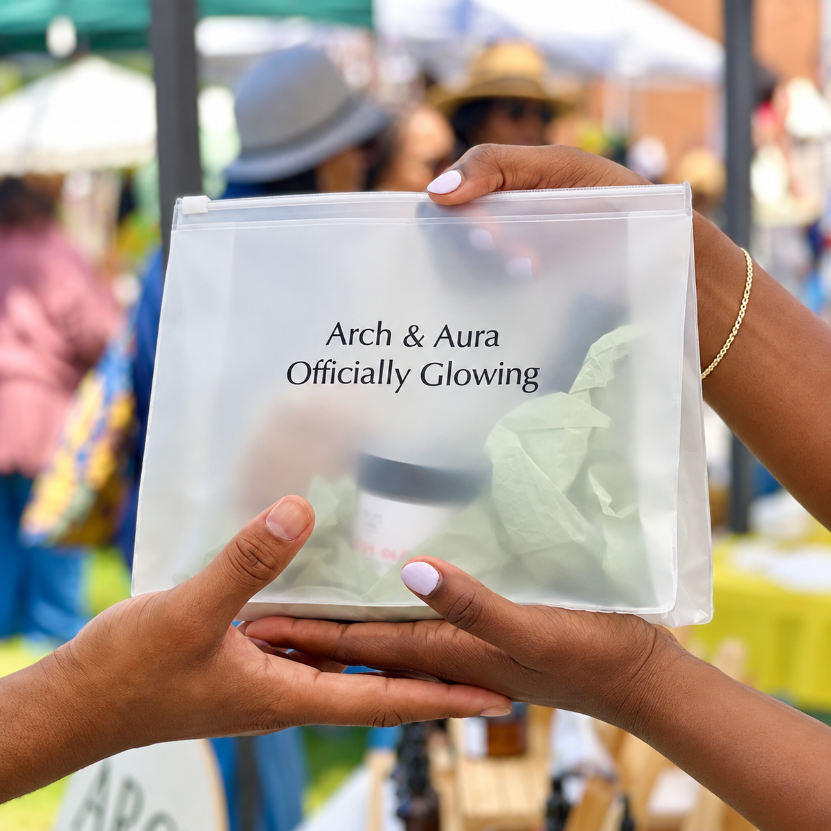 Arch and Aura Officially Glowing bag of natural handcrafted skincare handed to a customer at a Richmond, VA market